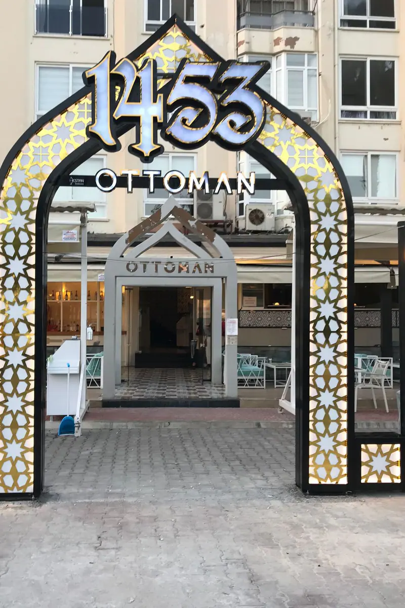 Altın desenli ışıklı kemer tabelanın dikey görünümü, restoran girişi